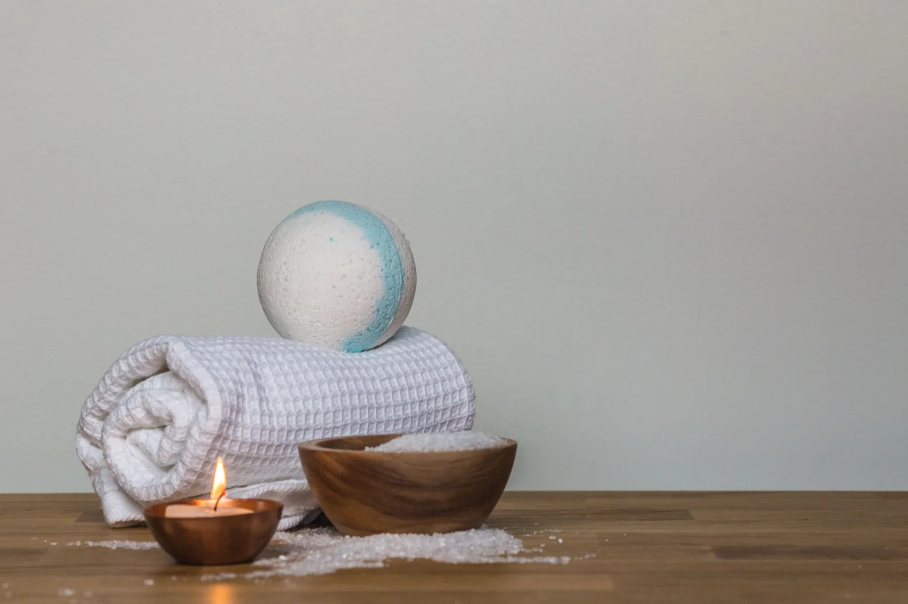 Rolled towels, bath salts and a candle